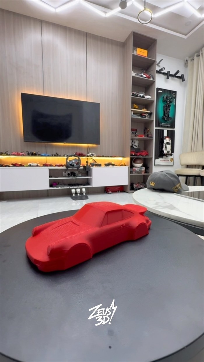 A red 3D-printed car model on a table.