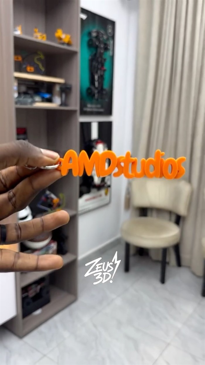 A 3D-printed logo sign held up in a showroom.