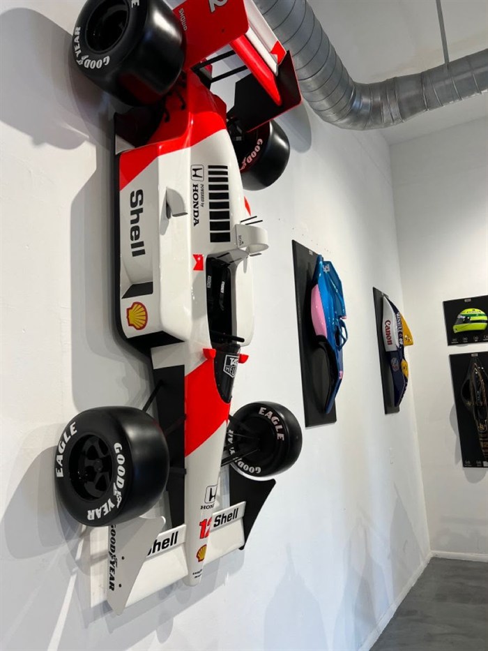 A 3D-printed McLaren Formula 1 car mounted in a corridor.